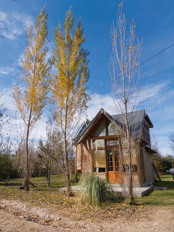 a small house with trees in front of it at Arrullo del viento in Villa Yacanto
