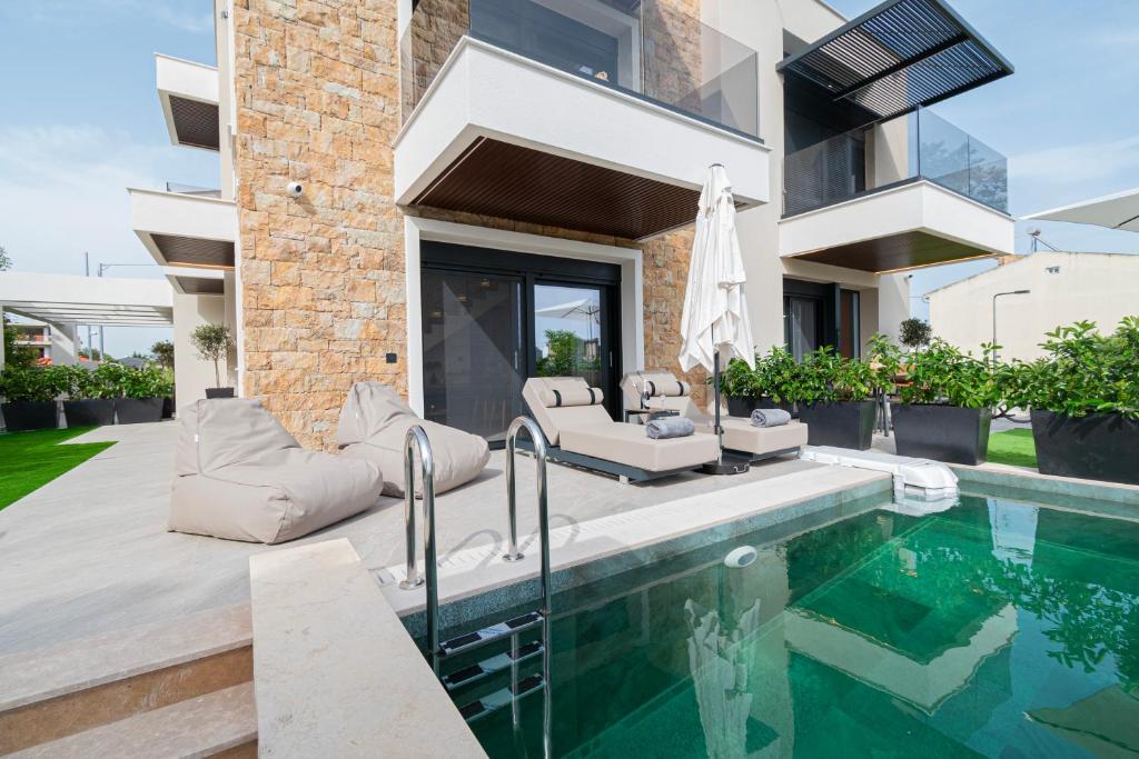 a home with a swimming pool and a house at Trithiron Luxury Villas in Nea Moudania