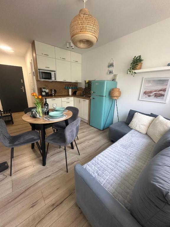a living room with a couch and a table at Apartamenty Modrzewiowa Enklawa in Debina