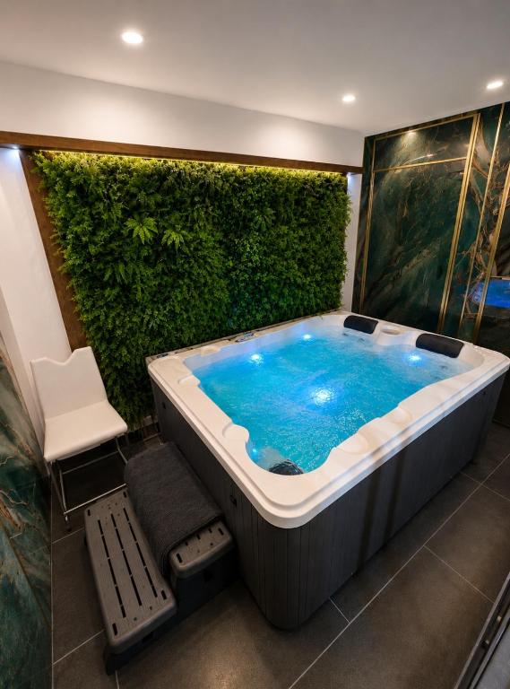 a bath tub in a room with a green wall at Apparte 104 avec Jacuzzi in Cap d'Agde