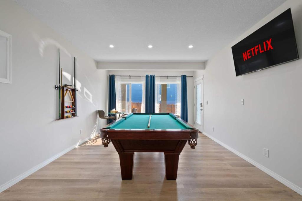 a pool table in a room with a window at Spacious 5BR, Hot Tub and Pool Table - Sleeps 16 in YYC