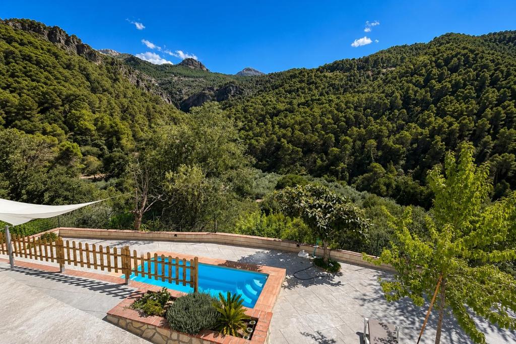 an outdoor swimming pool with a view of a mountain at Villa Río Béjar in Quesada