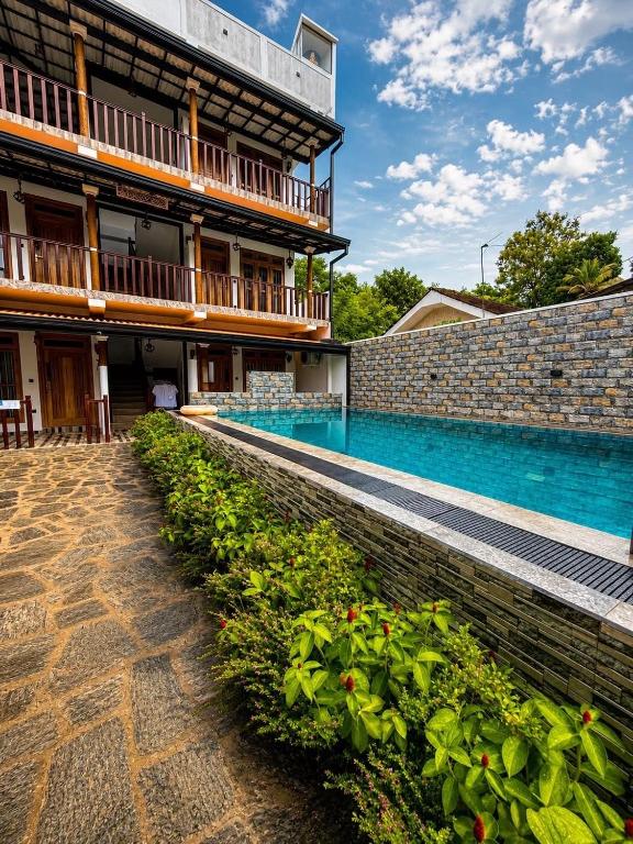 a swimming pool in front of a building at AZORA Boutique Studios in Ahangama