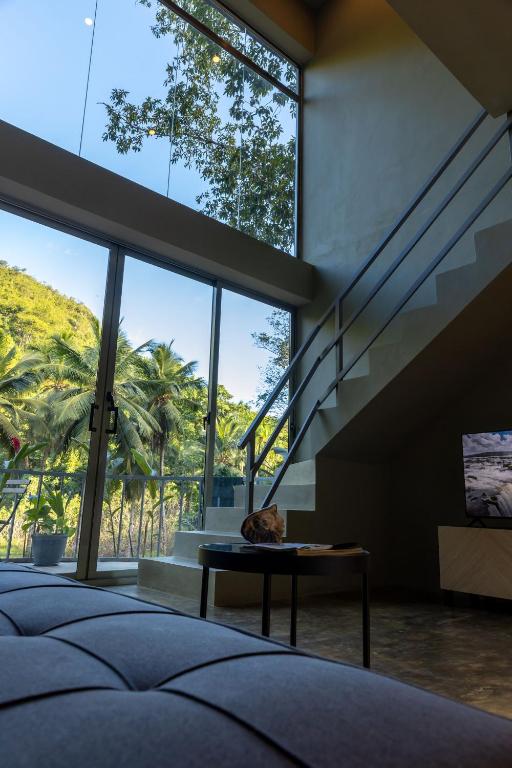 a bedroom with a large window and a staircase at Elegant and Stylish - Riverside Tiny House Apartment in El Valle