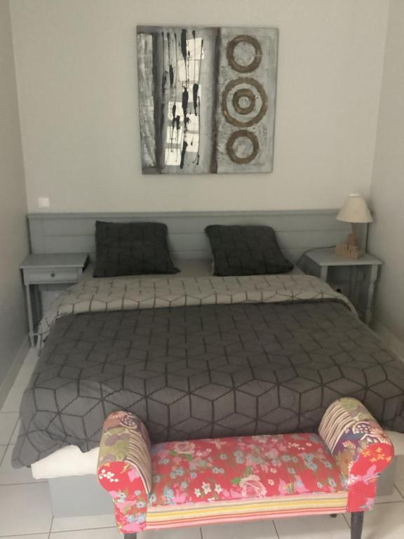 a bedroom with a bed with a bench in it at Chez titi et carole in Dissay-sous-Courcillon