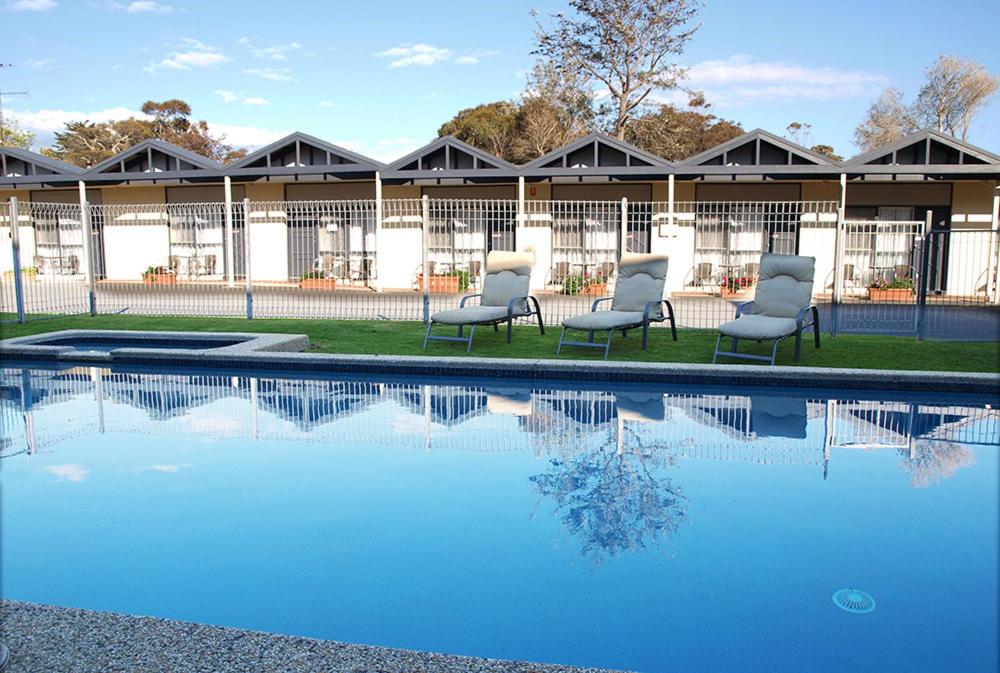 a group of chairs sitting next to a swimming pool at Mornington Motel in Mornington