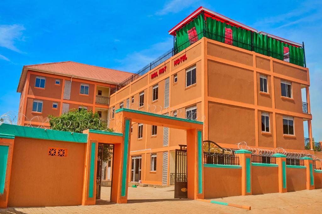 an orange building with a green roof at Mol Mot Hotel in Gulu