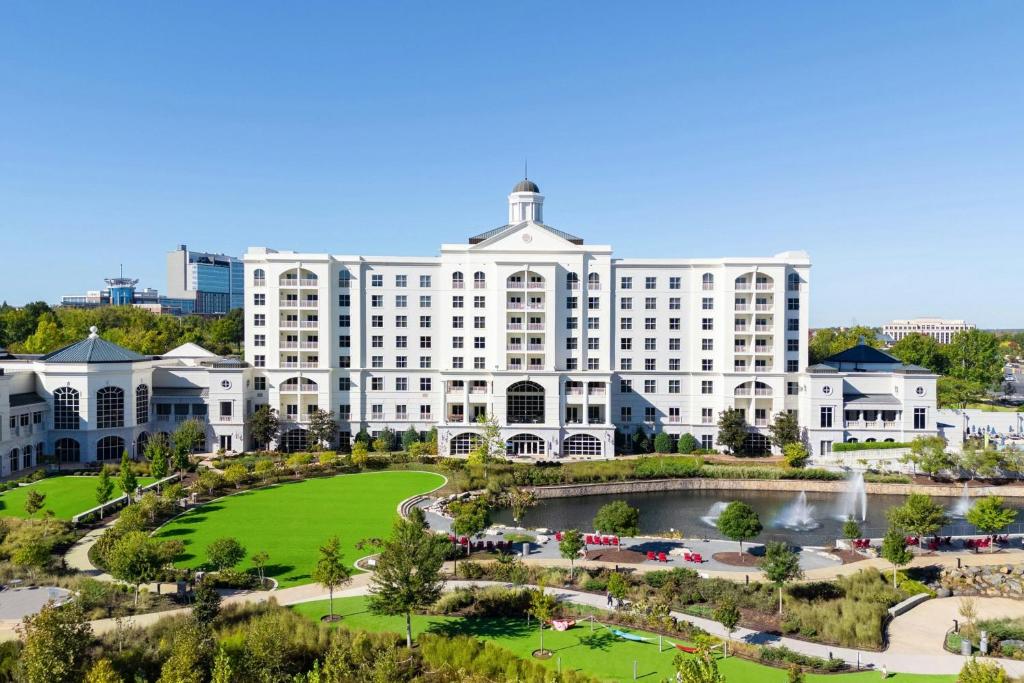 an aerial view of a large white building with a pond at The Ballantyne, a Luxury Collection Hotel, Charlotte in Charlotte