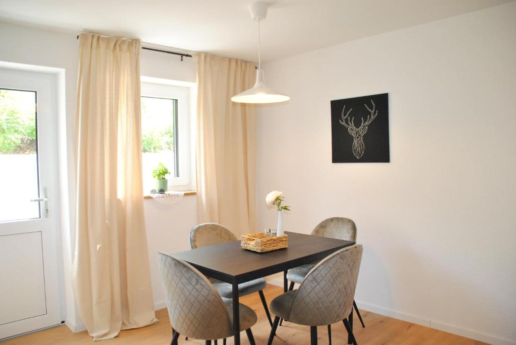 a dining room with a black table and chairs at Apartment la rosa in Weißensberg