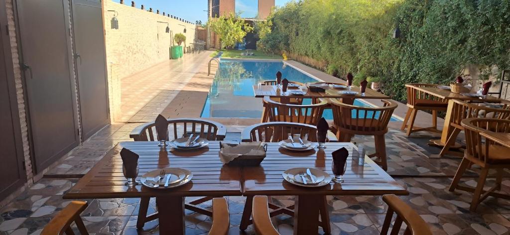 a restaurant with a table and chairs and a swimming pool at Dar margoum in Marrakesh