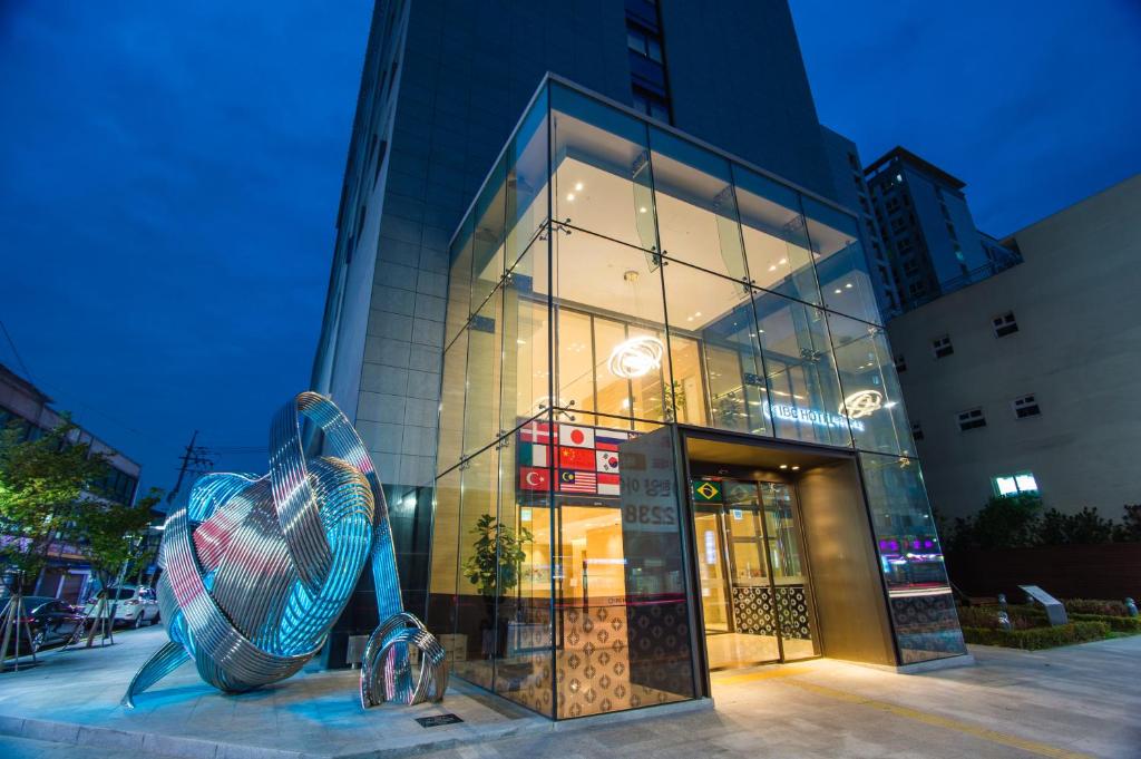 un gran edificio de cristal con una escultura delante en IBC Hotel Dongdaemun en Seúl