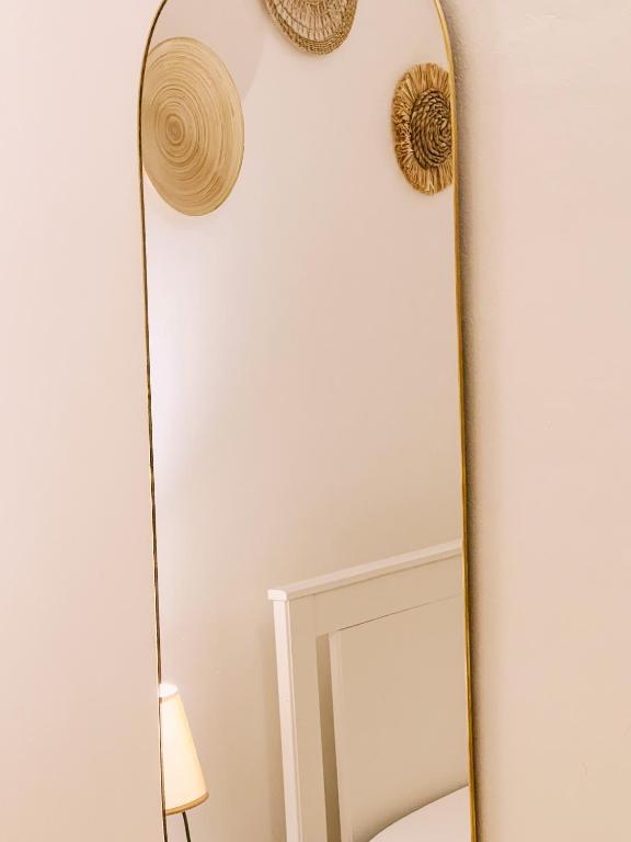 a mirror next to a wall with a lamp and a lamp at Civico 39 in Ostuni