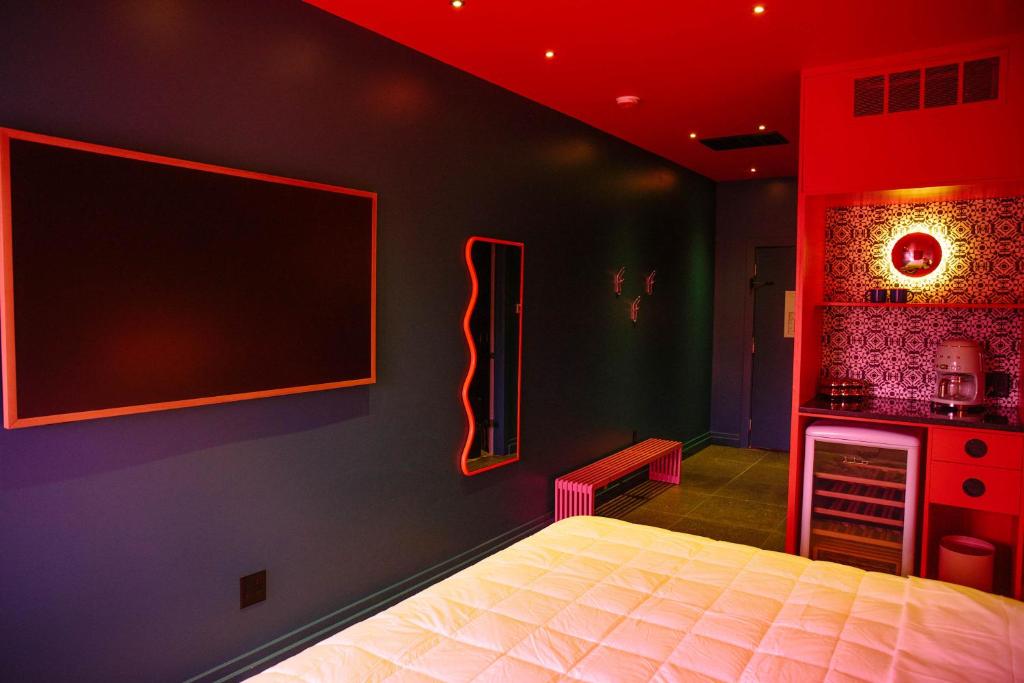 a bedroom with a bed and a tv on the wall at Hotel Hilo - Room 104 in Louisville