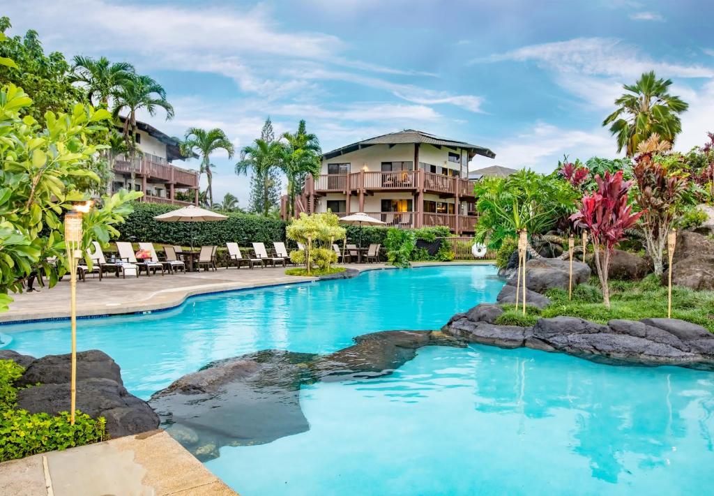 a resort swimming pool with a resort in the background at Ka Eo Kai Resort 2BR Villa in Princeville