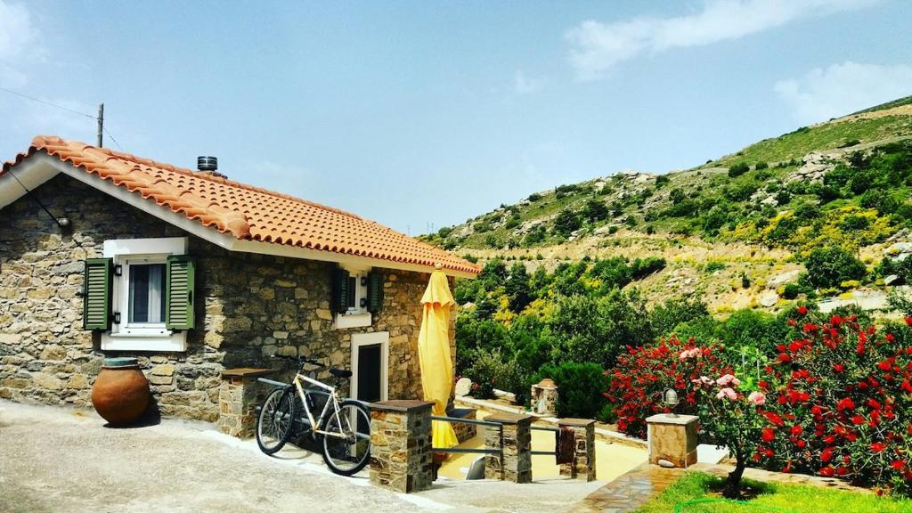 a house with a bike parked outside of it at Vrakades - Guest House in Kouniádhoi