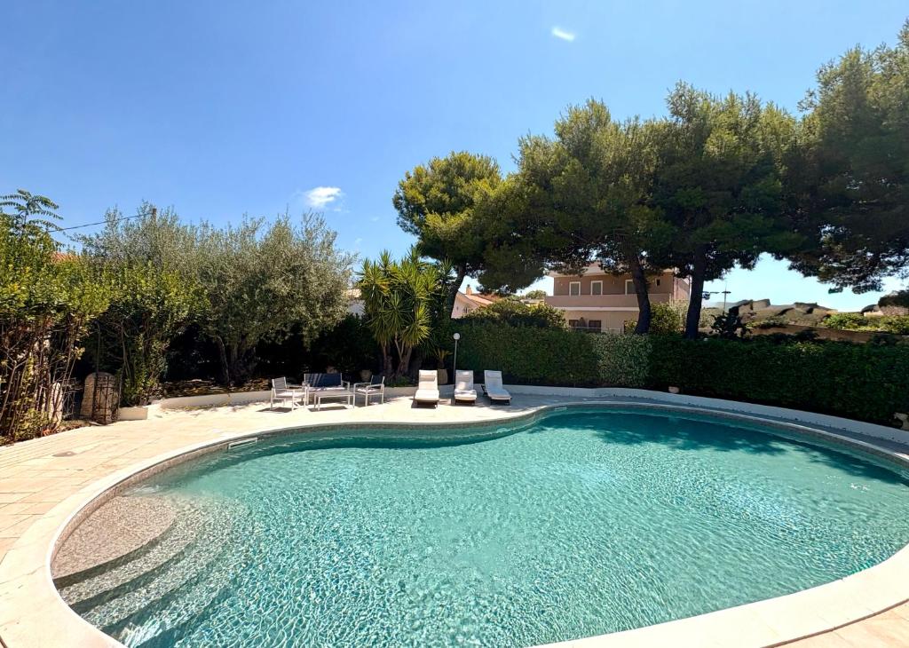 a swimming pool in a yard with chairs and trees at Il Calesse - Noto in Noto