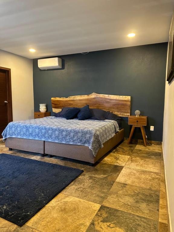 a bedroom with a large bed with a wooden headboard at Hotel La Bikina in Tequila