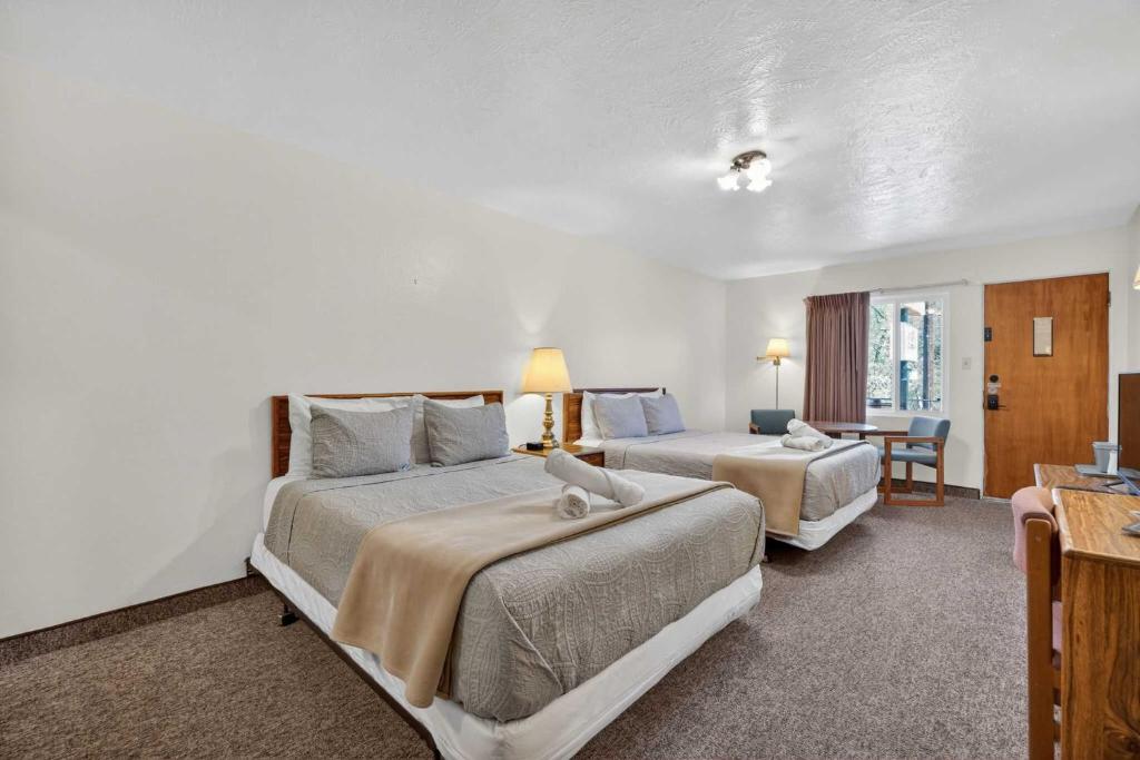 a hotel room with two beds and a table at Eagle Motel Suite 108 in Manitou Springs