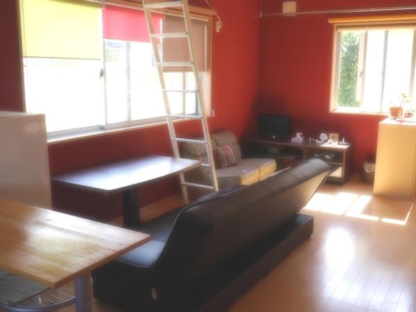 a living room with a couch and a ladder at Guest House Tomida in Ena