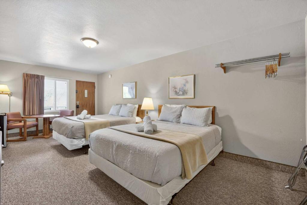 a hotel room with two beds and a table at Eagle Motel Suite 110 in Manitou Springs