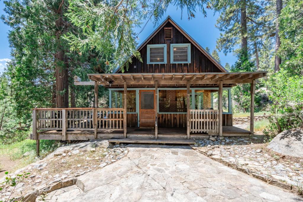 a house in the woods with a wrap around porch at Harmony Hideaway Hammocks Creek Sounds in Shaver Lake