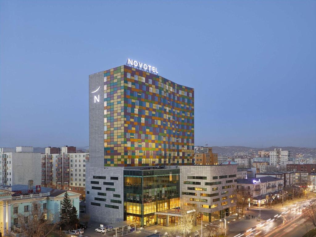 a tall building with a sign on top of it at Novotel Ulaanbaatar in Ulaanbaatar
