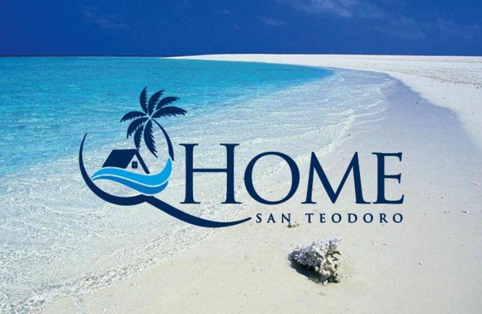 a beach with a sign that says home on it at Q Home San Teodoro Centro in San Teodoro
