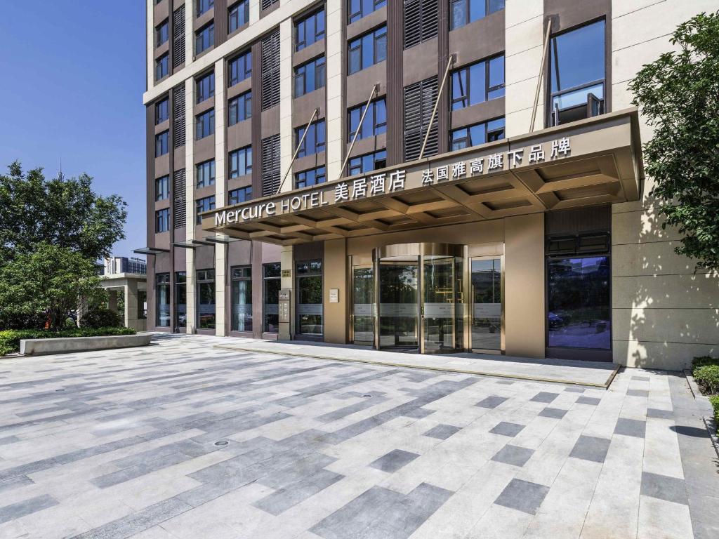 an empty parking lot in front of a building at Mercure Shanghai Jiuting in Shang-hai