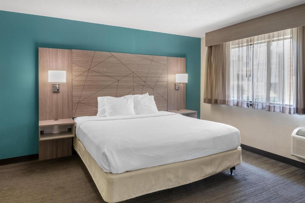 a bedroom with a large bed and a large window at Best Western Fishkill Inn & Suites in Fishkill