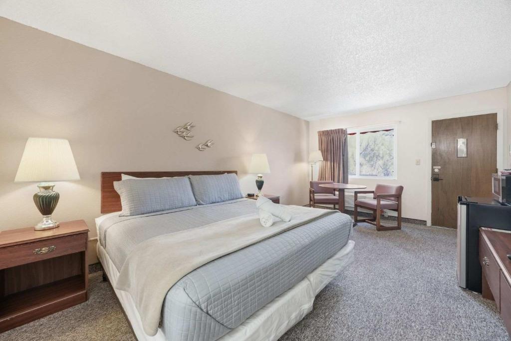 a bedroom with a large bed and a table and chairs at Eagle Motel Suite 226 in Manitou Springs
