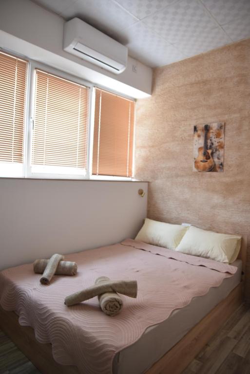 a bed with two logs on it in a bedroom at Apartment Friends in Veles