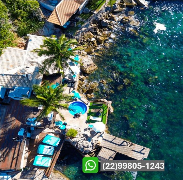 an aerial view of a beach with chairs and palm trees at Pousada Vista Grega in Arraial do Cabo