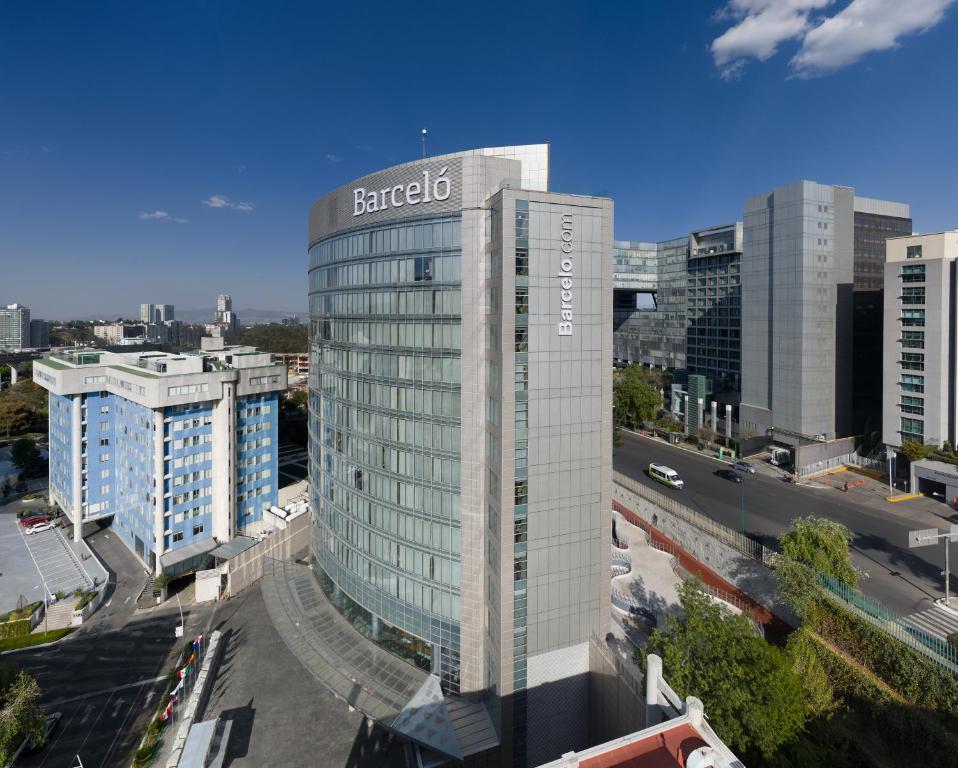 a tall building with a sign on it in a city at Barceló México Santa Fe in Mexico City