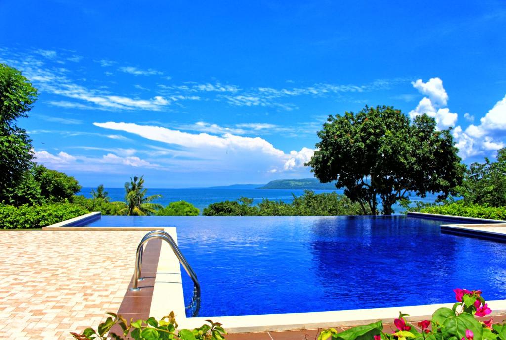 a swimming pool with a view of the ocean at Samawa Seaside Resort in Sumbawa Besar