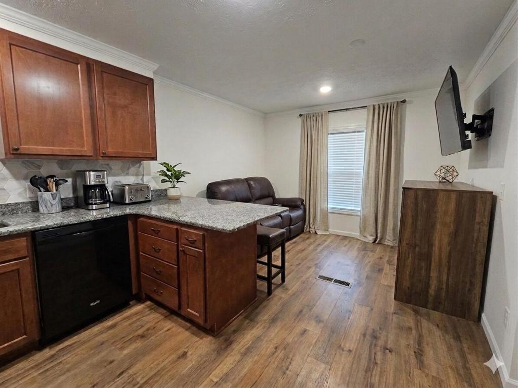 a kitchen with wooden cabinets and a counter top at Tiny Home with Grill Laundry Deck Desk in Phenix City