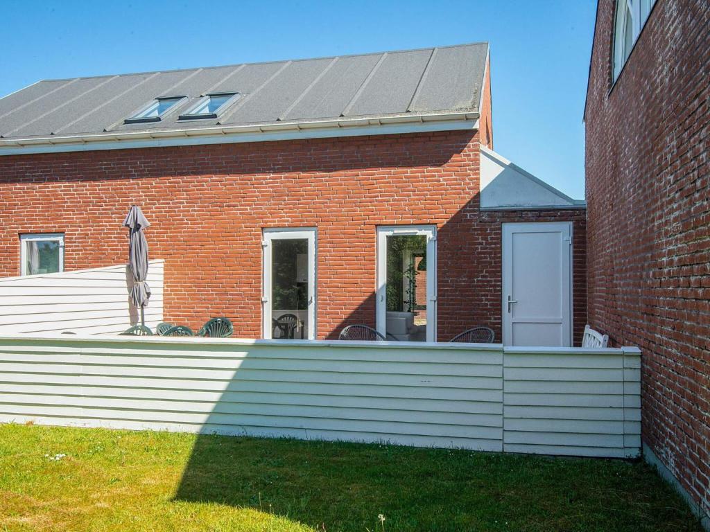 a red brick building with a solar roof at 6 person holiday home in Rømø-By Traum in Sønderby