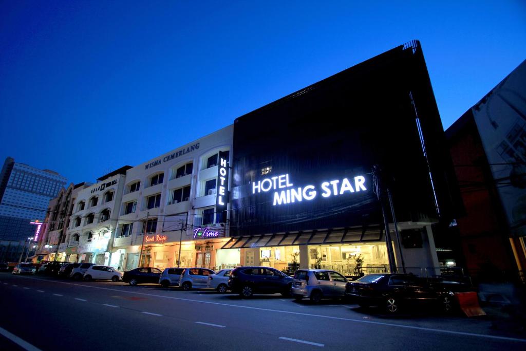 a large building with cars parked in front of it at Hotel Ming Star in Kuala Terengganu