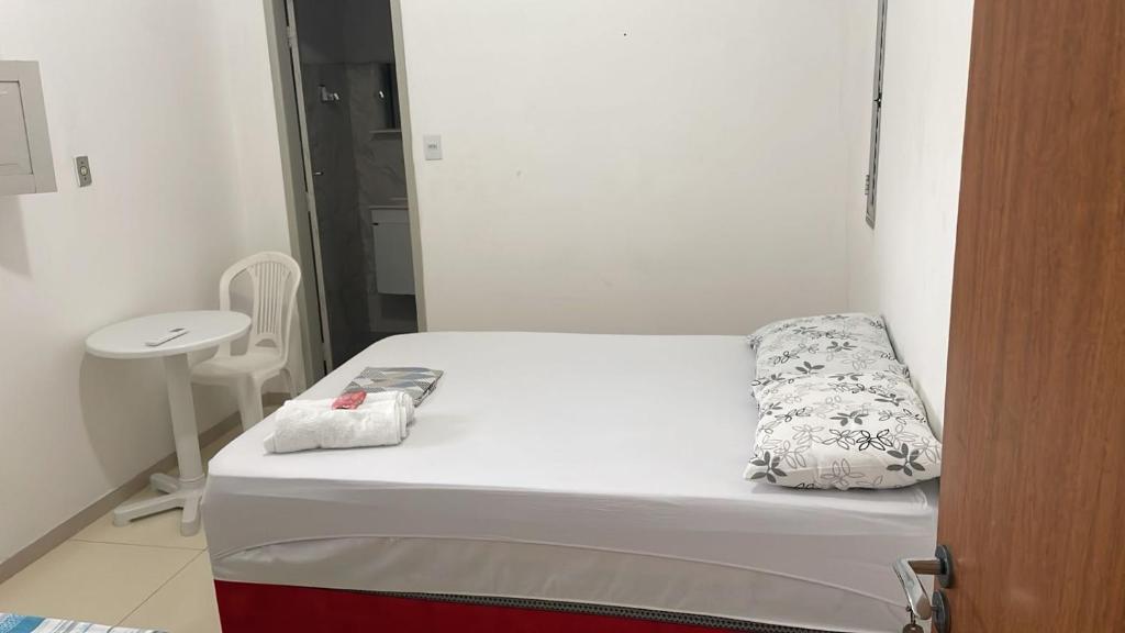 a small room with a bed and a table at Pousada Recanto Bella Vista in Saubara