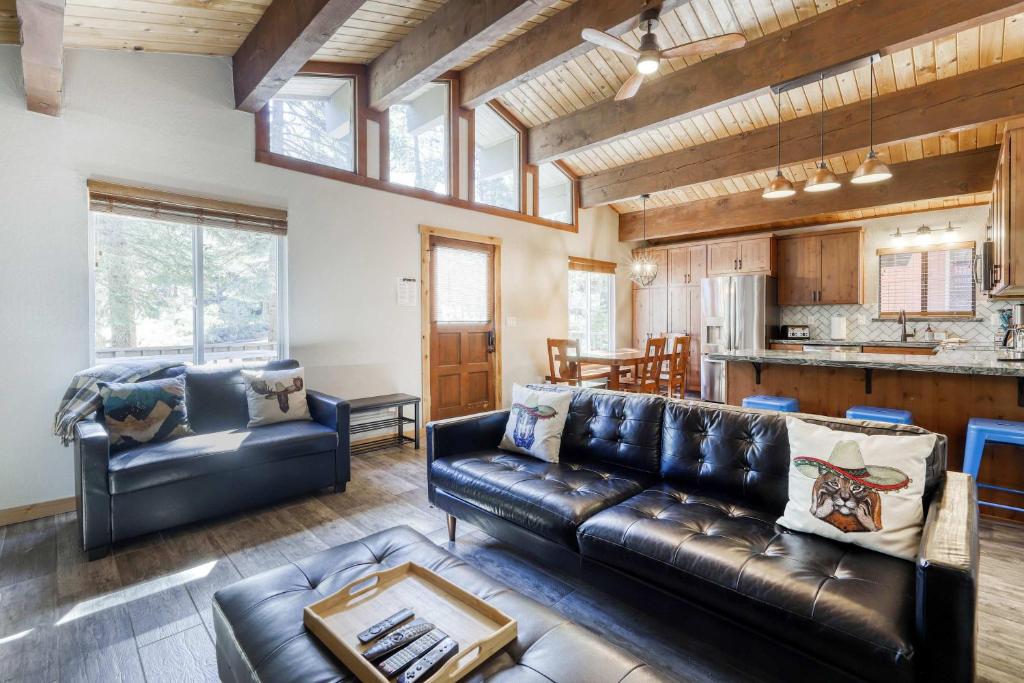 a living room with a leather couch and a kitchen at Northstar Cabin Escape in Truckee