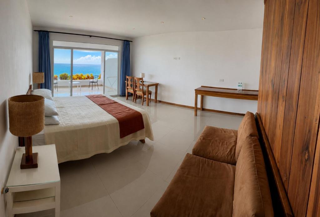a bedroom with a bed and a couch and a table at Hotel Punta Blanca - Jama - Manabí in Jama