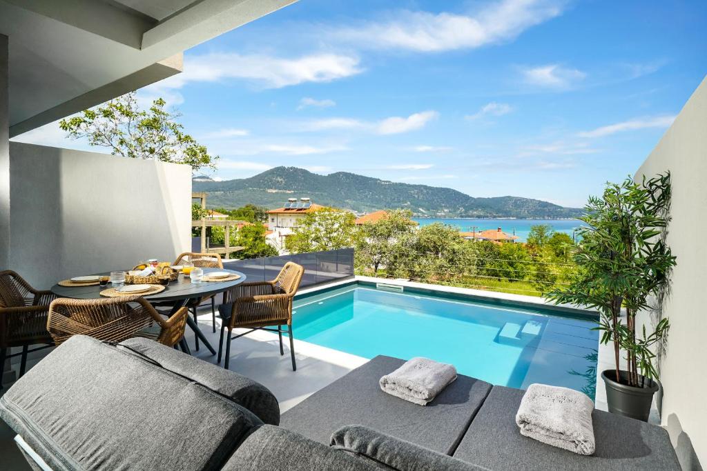 a patio with a table and chairs and a swimming pool at Ethos Zeen Private Pool Suites in Potamiá