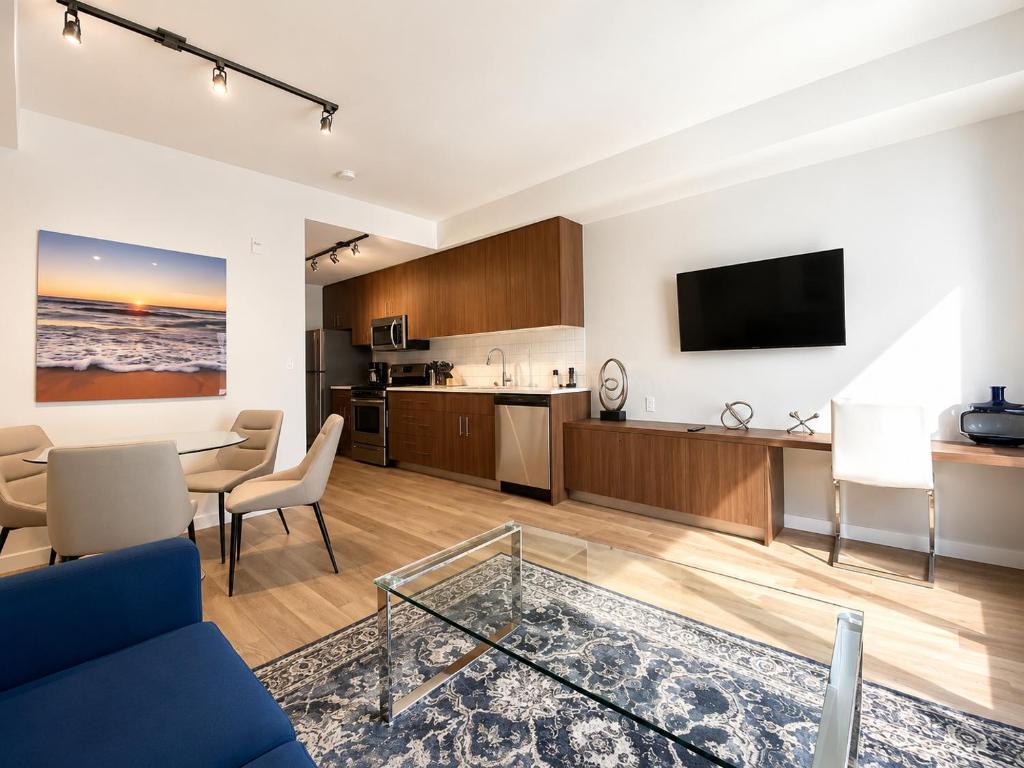 a living room with a blue couch and a table at Perfect Brand New Condo Downtown Sidney in Sidney