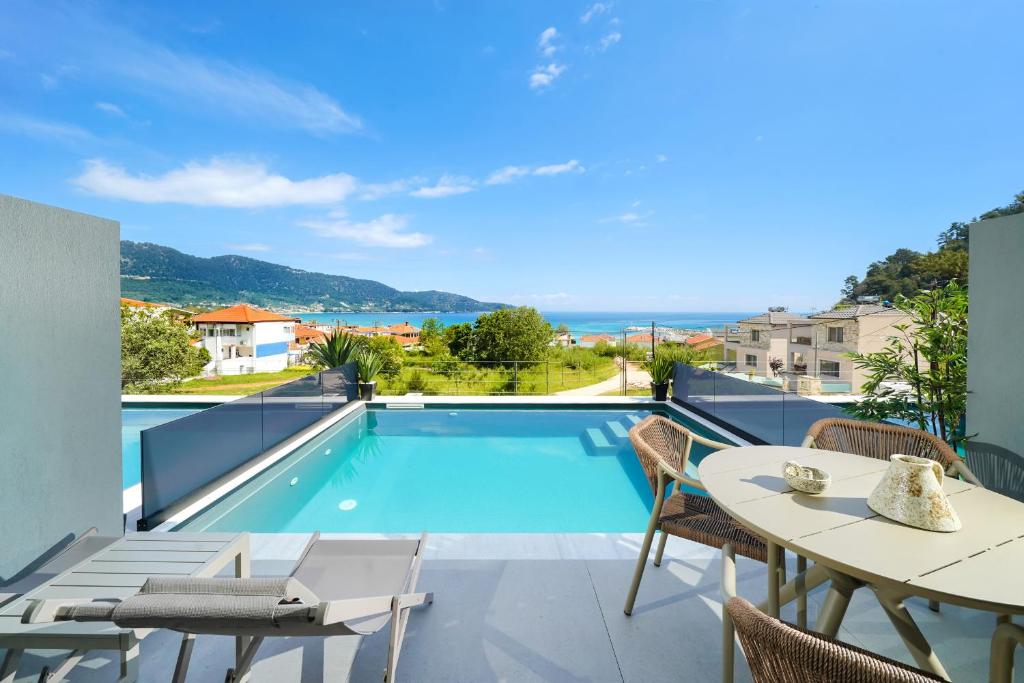 a patio with a pool and a table and chairs at Videre Golden Private Pool Suites in Potamiá