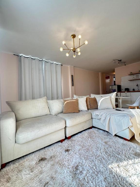 a living room with a white couch and a bed at Cozy house in San Pedro