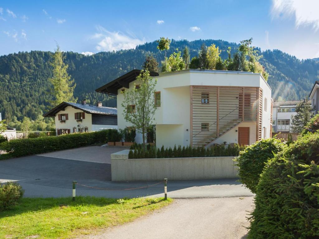 a house with a driveway in front of a mountain at Kitz Apartments Top 7 in Kitzbühel