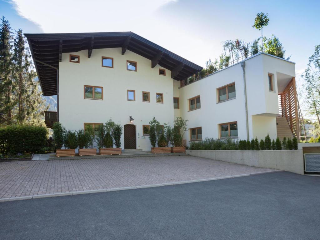 a large white house with a driveway at Kitz Apartments Top 1 in Kitzbühel