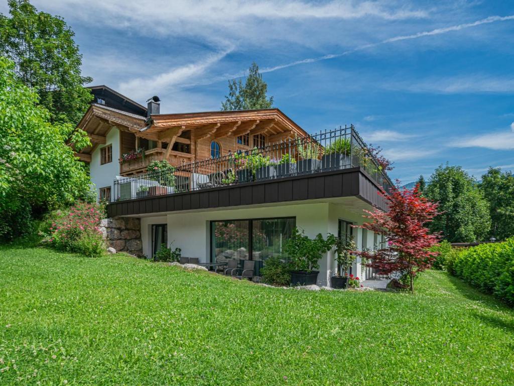 a house with a balcony on top of a yard at AlpenHerz in Jochberg