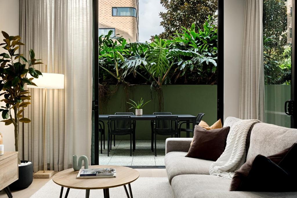 a living room with a couch and a table at Stylish CBD Apartment with Courtyard and Parking in Newcastle
