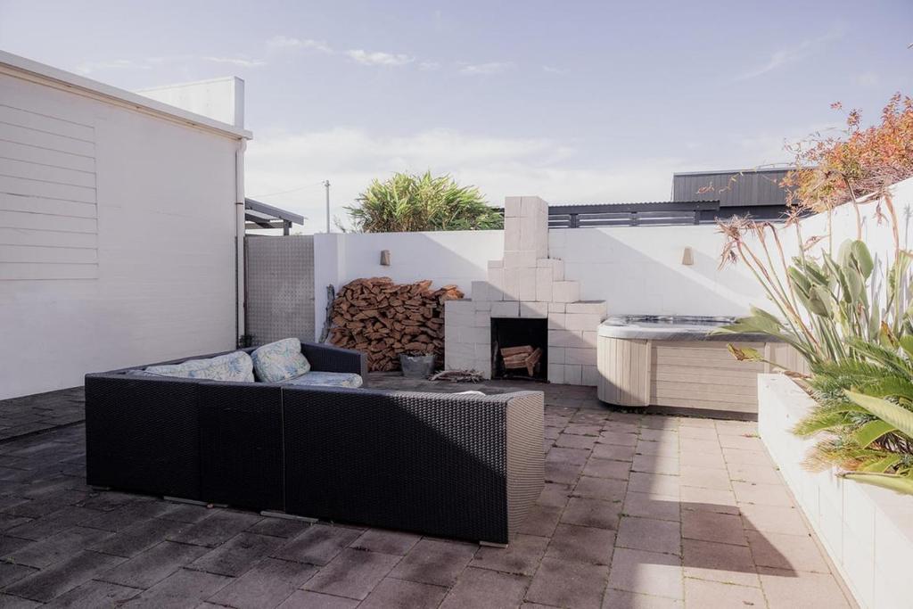 a patio with a couch and a fire place at Ruby SoHo Spa Villa in Port Sorell