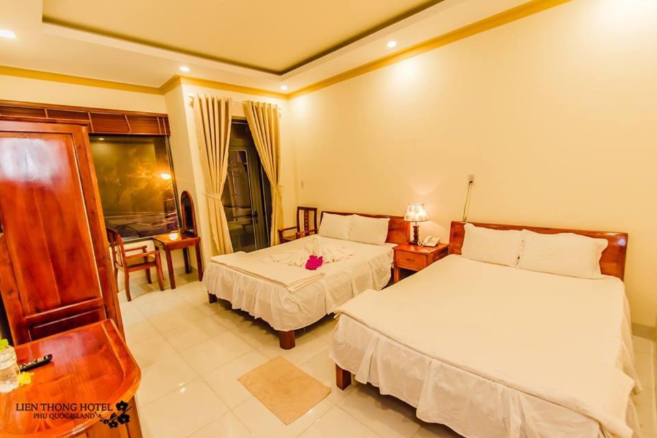 a bedroom with two beds and a table and chairs at Lien Thong Hotel in Phú Quốc